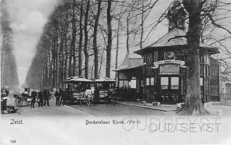 Donkerelaan-1903-001.jpg - Donkerelaan - Kiosk. Tot 1956 heette het begin van de Slotlaan Donkerelaan (vanaf de Postkantoor tot de 1e Hogeweg). Het openbaar vervoer bestond uit de paardentram waarvan hier 2 rijtuigen bij de kiosk staan te wachten om naar Driebergen-Station (S.S.) en Utrecht te vertrekken. De kiosk heeft later als wachtkamer bij het Station Bosch en Duin dienst gedaan. ( Zie Buurtschappen: Bosch en Duin) Opname van 1903.