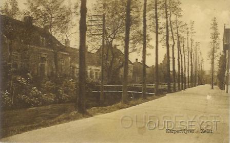 Karpervijver-1933-001.jpg - Karpervijver met bruggetjes. Vroeger werd de vijver ook wel “Achter de tuintjes” genoemd vanwege de tuinen van de Broedergemeente die er aan grenste. Aan deze straat hebben, links aan het einde, de rijwielfabriek “Wilhelmina” en zilverfabriek “Kempen en de Geer” gezeten. Rechts bevond zich de fabriek “Kraepelien & Holm”. Foto gemaakt in 1933.