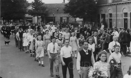 Bergweg-1950-006.jpg - Defilé avondvierdaagse op de Bergweg. Op de achtergrond bakkerij van Barneveld no: 64 en groentehandel van Stijn no: 62. Opname van omstreeks 1950. Wie herkent iemand op de foto of weet de juiste datum?