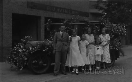 Middellaan-1930-002.jpg - Op de Middellaan no: 2-4, met garage van G. van Amersfoort, gevestigd aan de Slotlaan no: 39. Tel: 111. Op de foto is de familie Van Amersfoort te zien bij een versierde auto die mee gaat doen met een bloemencorso. Opname vermoedelijk 1931.