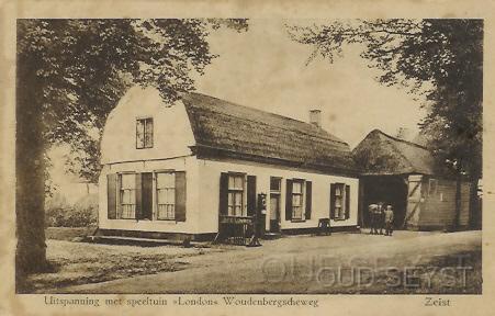 Woudenb.weg-1926-005.jpg - Foto van uitspanning “Oud London” Toen in 1830 de Woudenbergsche straatweg bestraat werd, begon de Duits-Zwitserse familie Reither een herberg genaamd “London”. De naam is ontleend aan een gelijknamig schip wat de familie naar Amerika zou brengen. De kapitein had de familie echter bedrogen en heeft ze, na betaling, nooit opgehaald in Rotterdam. De volledig aan lager wal geraakte familie Reither kreeg van de gemeente Zeist een stuk grond teogewezen waar ze zich konden vestigen en waar ze hun herberg zijn begonnen. Het huidige “Oud London” lijkt in niets meer op het pand van de foto. Foto gemaakt in 1926.